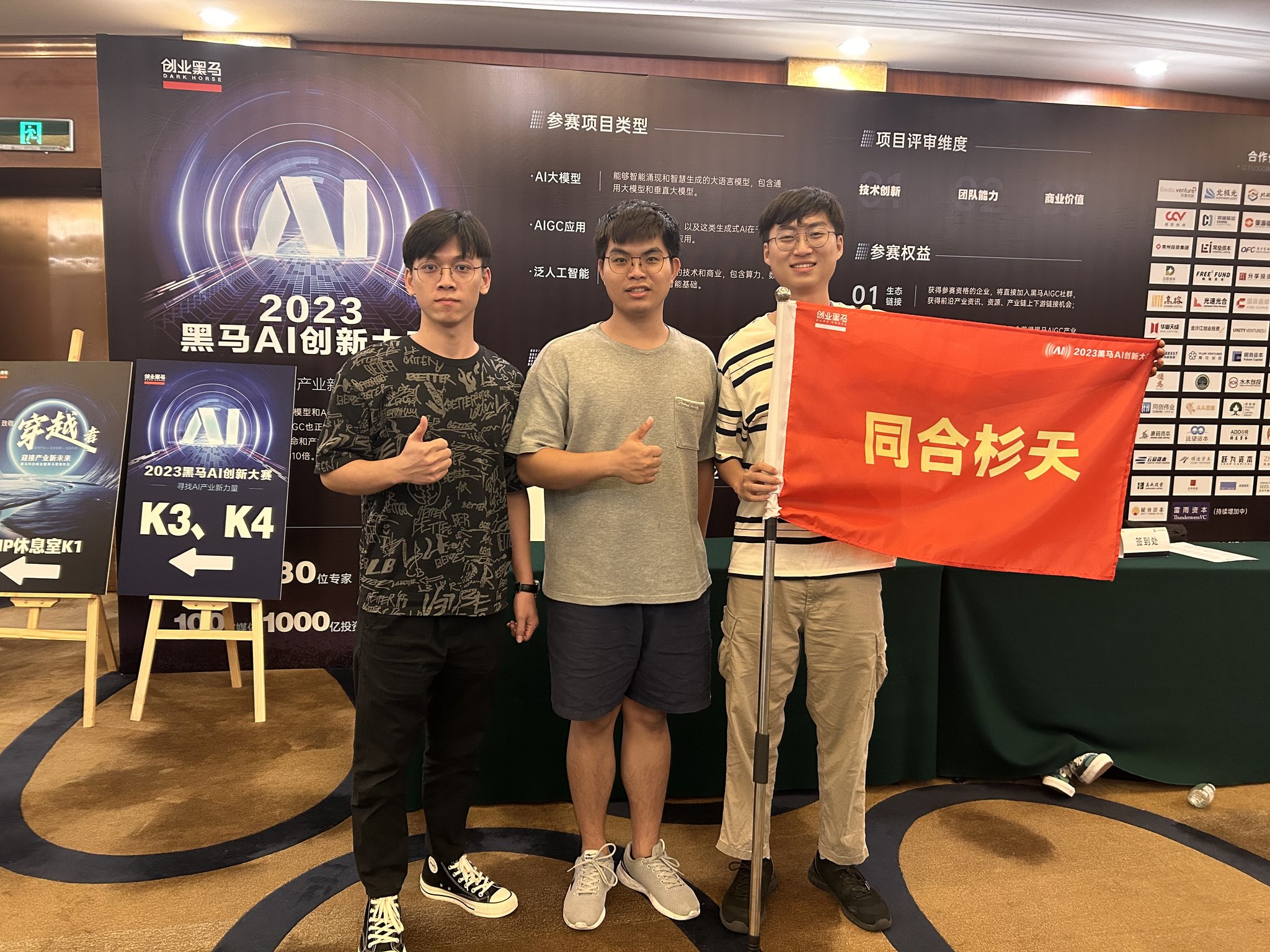 團隊在 2023 黑馬 AI 創新大賽現場舉著同合杉天旗幟